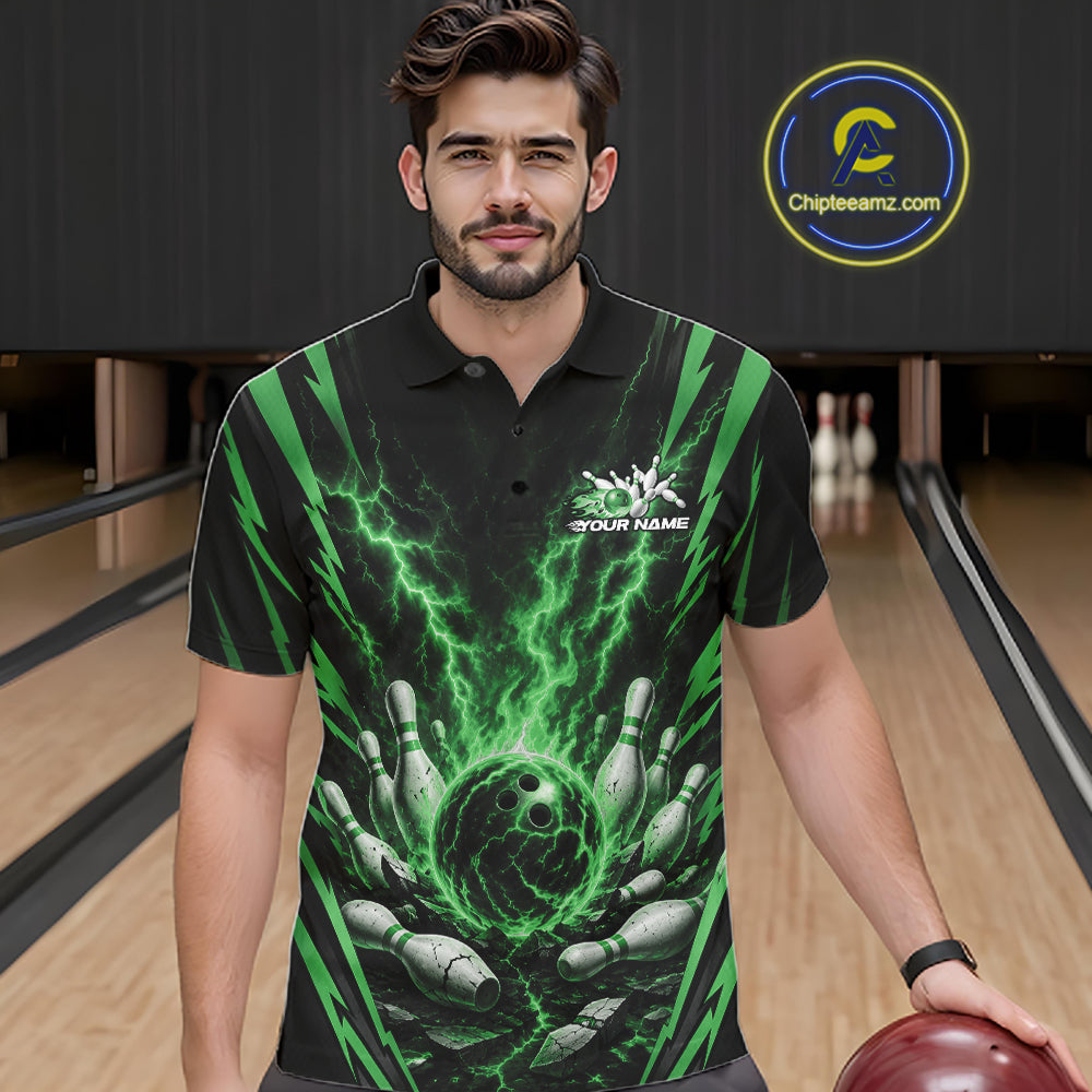 A man wearing a black short-sleeve polo shirt with a green lightning and bowling pin graphic, standing in a bowling alley. 