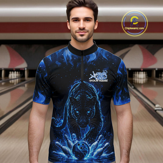 Front view of a male model in a bowling lane wearing a black quarter-zip shirt with glowing blue electric panther and energetic bowling strike graphics.