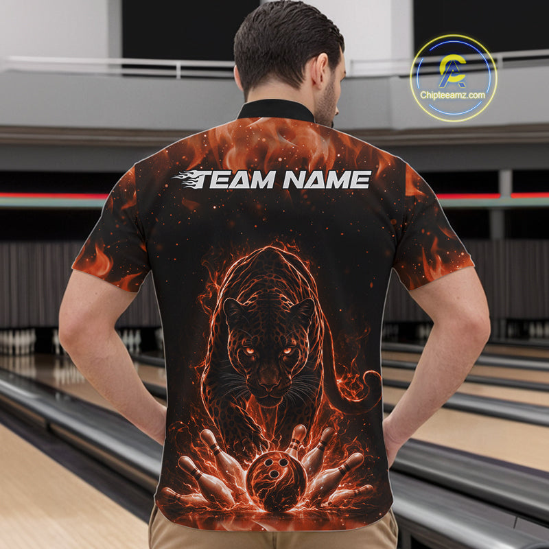 Front view of a male model in a bowling lane wearing a black quarter-zip shirt featuring glowing orange electric panther artwork with bowling ball striking pins.