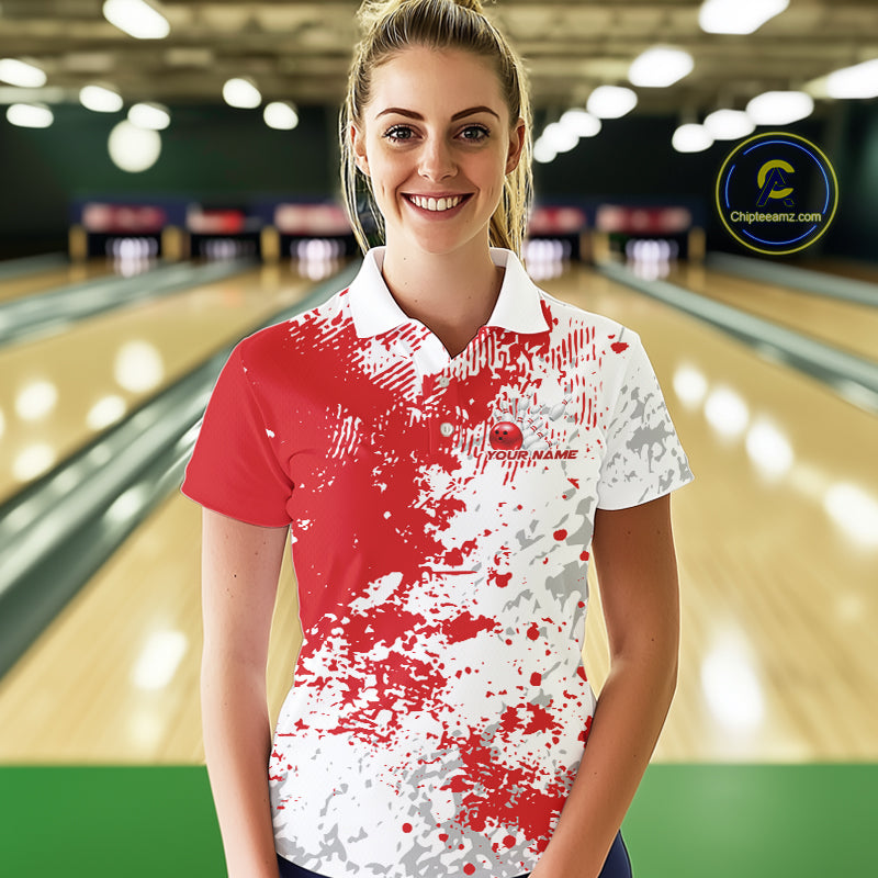 Female model front view in bowling lane wearing white polo shirt with red and white splatter pattern, sporty bowling alley scene
