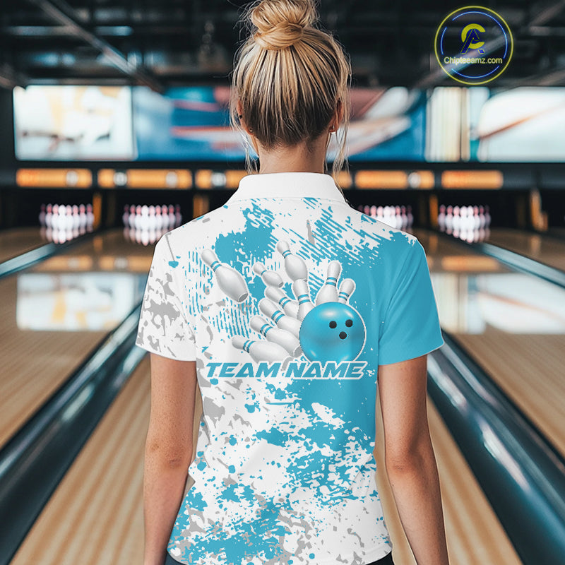 Back view of a female model in a bowling lane wearing a teal blue and white splatter bowling quarter-zip shirt with sporty bowling-inspired design accents.