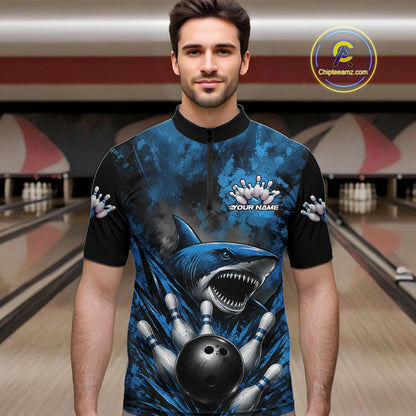 Man wearing a blue and black bowling shirt with shark design in a bowling alley.
