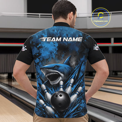 Person wearing a blue and black bowling shirt with a shark design in a bowling alley.