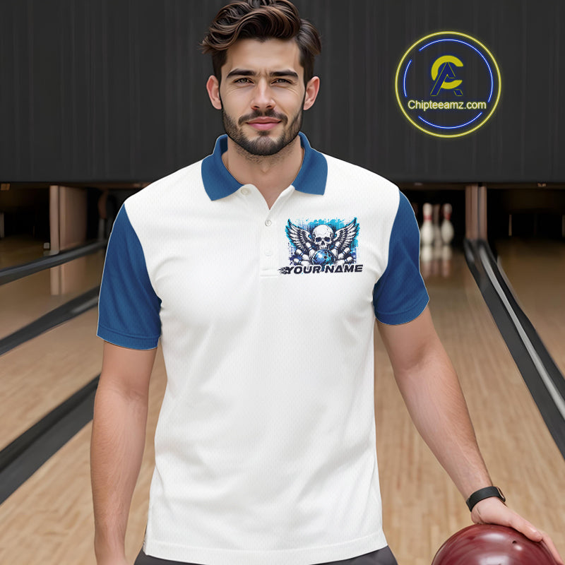 Front view of a male model in a bowling alley wearing a bowling polo shirt featuring a gothic skull with wings, bowling ball, pins, and ornamental swirls with a personalized name on a white and blue design.

