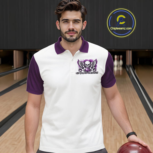 A man stands in a bowling alley wearing a bowling shirt with polo collar, purple skull-themed bowling graphic with black wings, pins, bowling ball