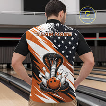 Load image into Gallery viewer, Back view of a man in a bowling alley wearing a black, white, and orange american flag cobra-themed shirt with “Team Name” across the shoulders.