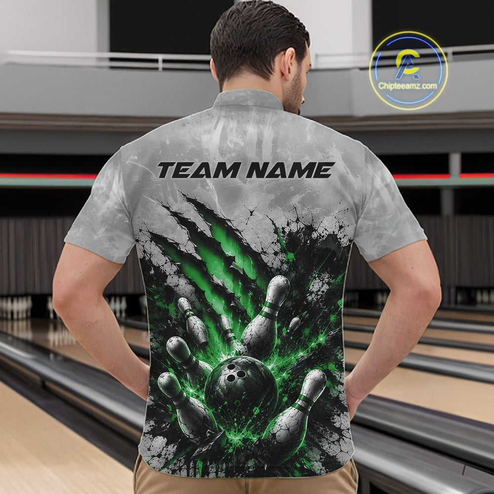 Front view of a male model wearing a gray bowling quarter zip shirt featuring a dramatic green bowling ball and pins graphic with claw-mark artwork in a bowling lane.