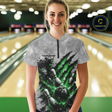 Load image into Gallery viewer, Front view of a female model wearing a gray bowling quarter zip shirt showcasing a dramatic green bowling ball and pins graphic with claw-mark artwork in a bowling lane.