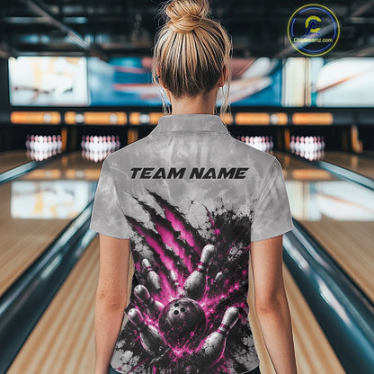 Back view of a female model wearing a gray bowling quarter zip shirt showcasing a dramatic pink bowling ball and pins graphic with claw-mark artwork in a bowling lane.