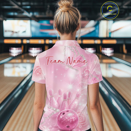 Back view of a female model in a bowling lane wearing a quarter-zip bowling shirt featuring pink glitter butterflies, bowling pins, and bowling ball artwork.