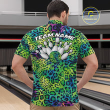 Load image into Gallery viewer, Back view of a man standing at a bowling alley, wearing a blue, green, and black leopard-print bowling polo with “Team Name” and bowling pins on the back.
