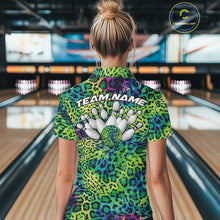 Load image into Gallery viewer, Back view of a woman standing at a bowling alley, wearing a green, blue, and black leopard-print bowling polo with “Team Name” and bowling pins on the back.