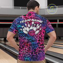 Load image into Gallery viewer, Back view of a man standing at a bowling alley, wearing a blue, purple, pink, and black leopard-print bowling polo with “Team Name” and bowling pins on the back.
