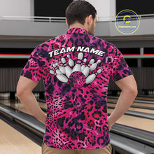 Load image into Gallery viewer, Back view of a man standing at a bowling alley, wearing a pink, purple, and black leopard-print bowling polo with “Team Name” and bowling pins on the back.
