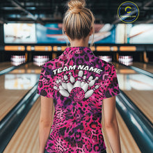 Load image into Gallery viewer, Back view of a woman standing at a bowling alley, wearing a pink, purple, and black leopard-print bowling polo with “Team Name” and bowling pins on the back.