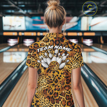 Load image into Gallery viewer, Leopard print bowling team shirt shown on a women facing the lanes, with a back design of bowling pins, a spotted ball, and customizable team name lettering.