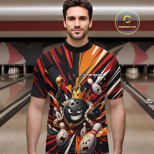 Front view of a male model wearing a black, red, and orange bowling quarter zip shirt featuring a crowned cartoon bowling ball holding a royal scepter with animated bowling pins and vibrant burst graphics in a bowling lane.