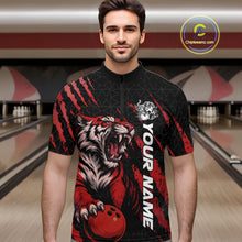Load image into Gallery viewer, Front view of a male model at a bowling lane wearing a black and red bowling quarter-zip shirt featuring a roaring tiger holding a red bowling ball with matching red claw-stripe artwork and a geometric background pattern.