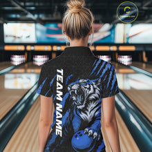 Load image into Gallery viewer, Back view of a female model in a bowling lane wearing a black and mid blue bowling quarter-zip shirt featuring a roaring tiger holding a mid blue bowling ball with coordinated claw-stripe graphics and a geometric background pattern.