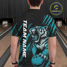 Load image into Gallery viewer, Back view of a male model wearing a black and teal blue bowling polo shirt in a bowling lane, featuring a roaring tiger holding a teal blue bowling ball with teal blue claw-stripe artwork and a geometric background pattern.
