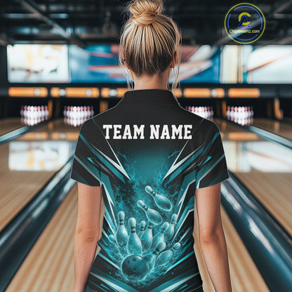 Back view female model in bowling lane wearing black and turquoise blue quarter zip featuring flaming bowling ball striking pins with dynamic fiery graphics.