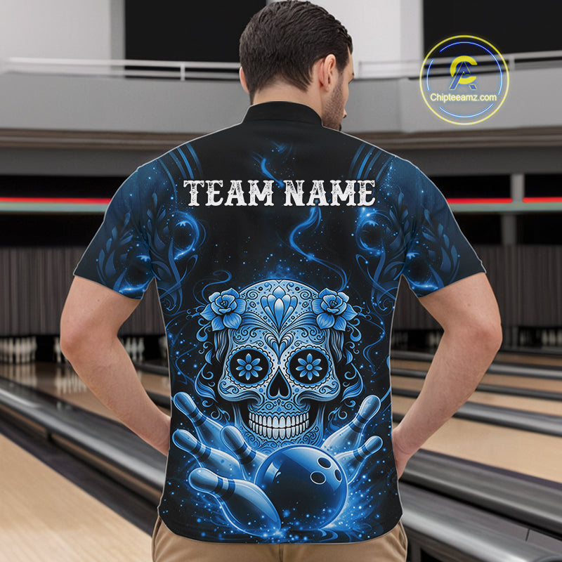 Front view of a male model in a bowling alley wearing a black and blue bowling quarter-zip featuring a floral sugar skull above bowling pins.