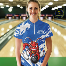 Load image into Gallery viewer, Front view of a happy female model in a bowling alley wearing a blue custom quarter zip bowling shirt with an aggressive crawfish bowling design and a distressed background.