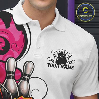 A close-up of a person wearing a white short-sleeve polo shirt with a bowling-themed graphic print on the left side and a black chest logo featuring a crown, bowling pins, and the text 'YOUR NAME'