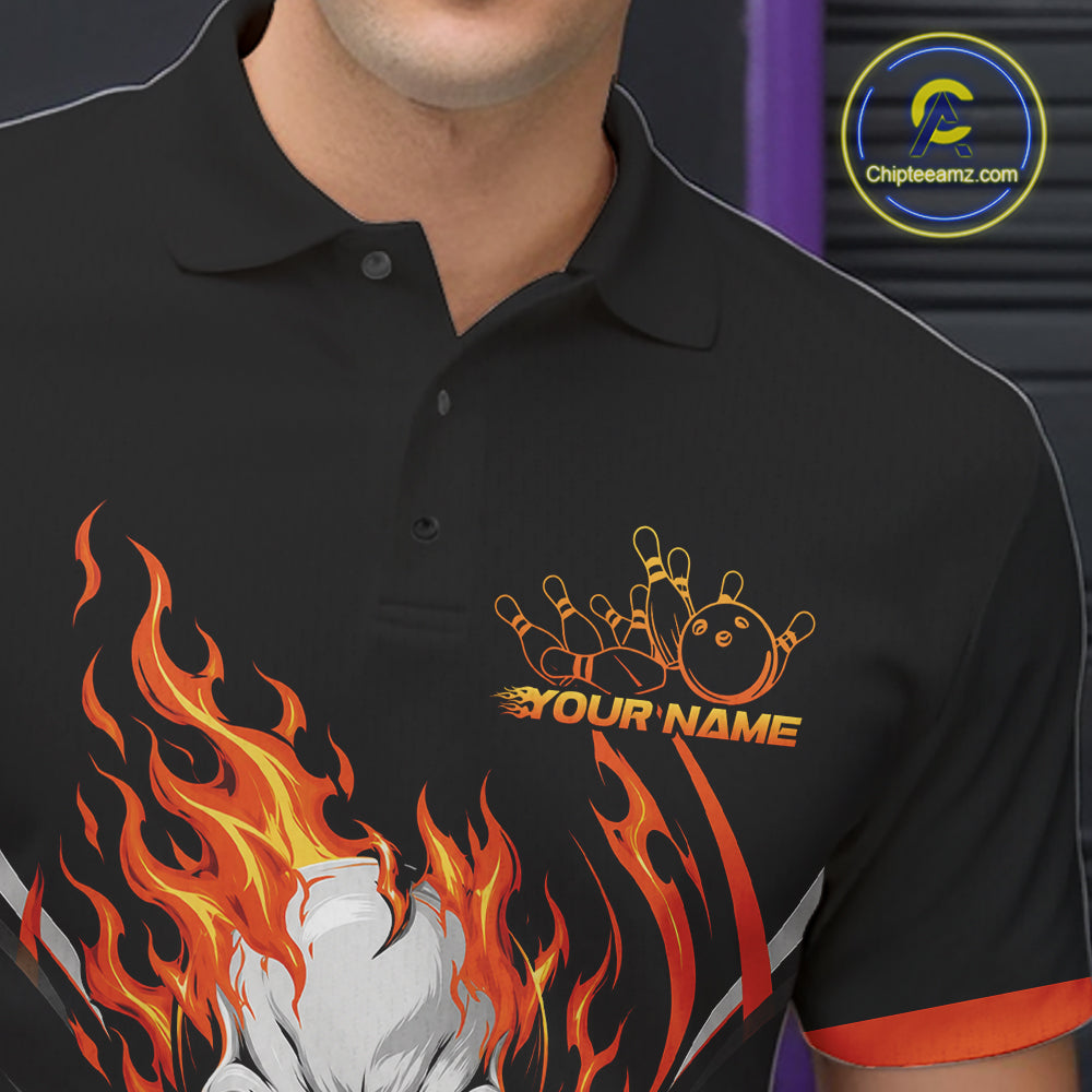 A close-up of a black polo shirt worn by a model, featuring a custom bowling-themed graphic with orange and yellow bowling pins, a bowling ball, and the text 'YOUR NAME' integrated into flames. The shirt also has orange and white trim on the sleeve and collar.