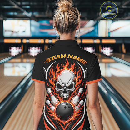 A woman viewed from behind wearing a black bowling-themed short-sleeve quarter zip shirt with a large skull, bowling pins, and orange flames graphic on the back, standing in a bowling alley.