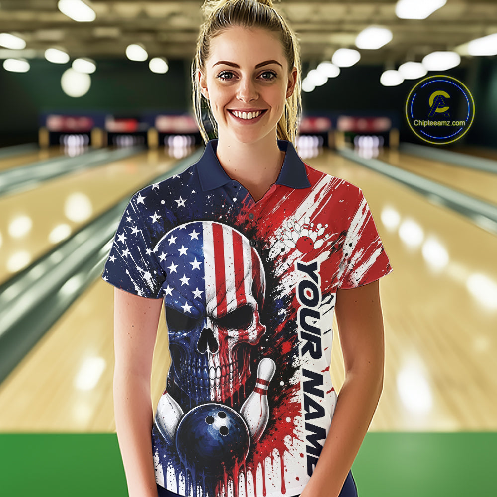 A woman wearing a custom bowling polo shirt with a patriotic American flag design, featuring a skull and bowling ball graphic, standing in a bowling alley.