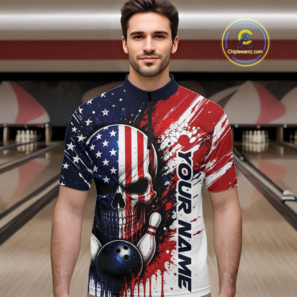 A man wearing a short-sleeve bowling quarter zip shirt with a patriotic American flag design, featuring a skull and bowling ball graphic, set against a blurred bowling alley background. 