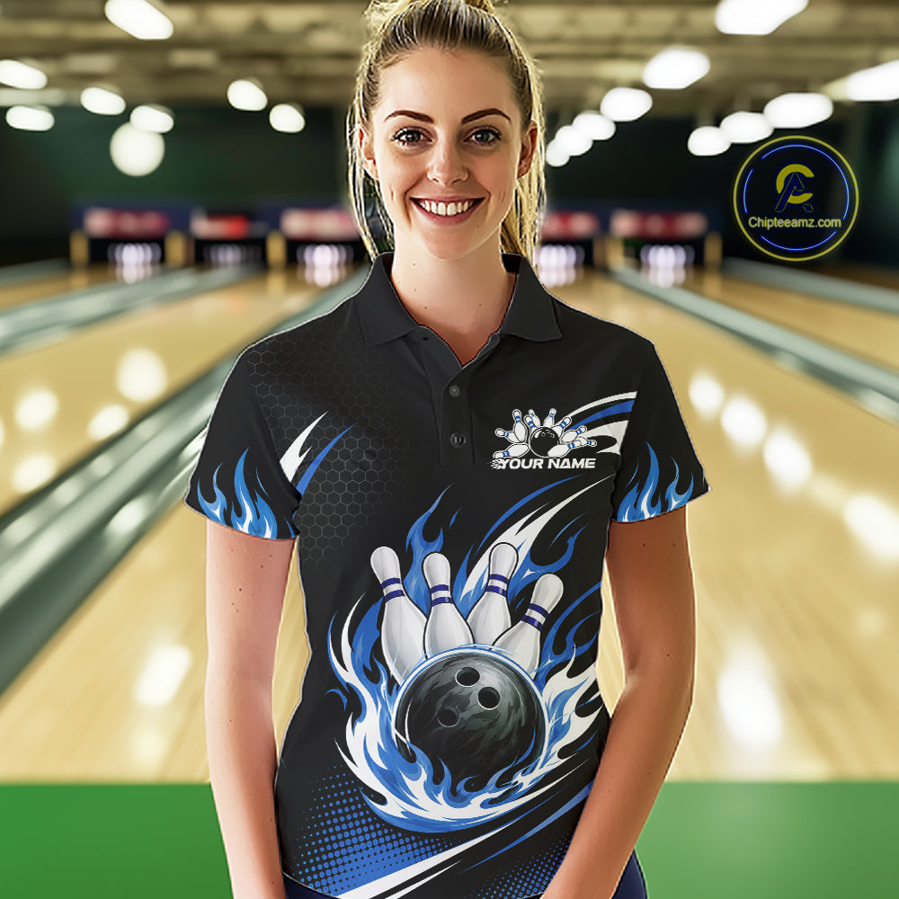 A woman wearing a custom black bowling polo shirt with blue flame graphics and a bowling pin/ball graphic on the front, standing in a bowling alley.