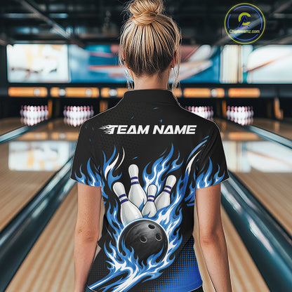 A woman viewed from behind wearing a black bowling-themed short-sleeve shirt with a blue and white flame graphic, bowling pins, and a bowling ball on the back, standing in a bowling alley.