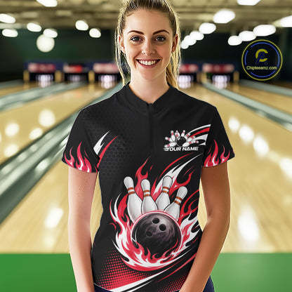 A woman wearing a black bowling-themed short-sleeve quarter zip shirt with red and white flame graphics, a bowling pin and ball design on the front
