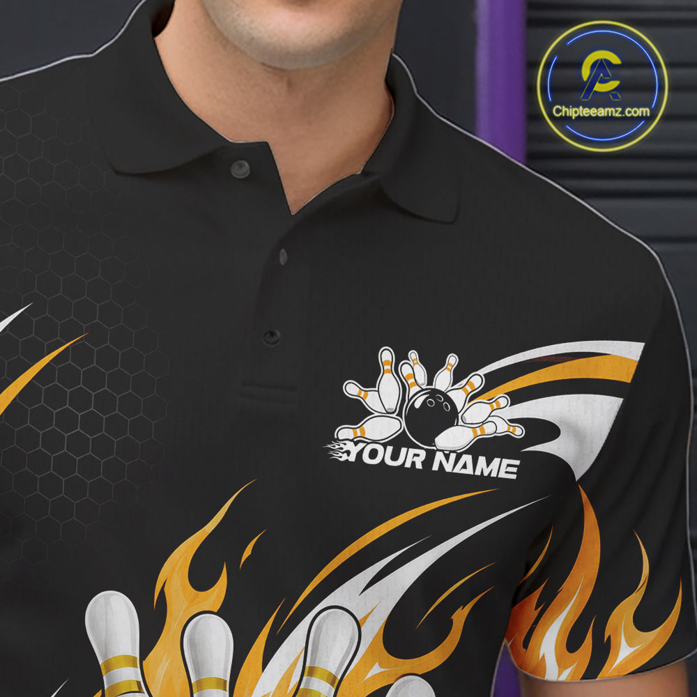A close-up of a black short-sleeve polo shirt with yellow flaming bowling ball and pin graphics