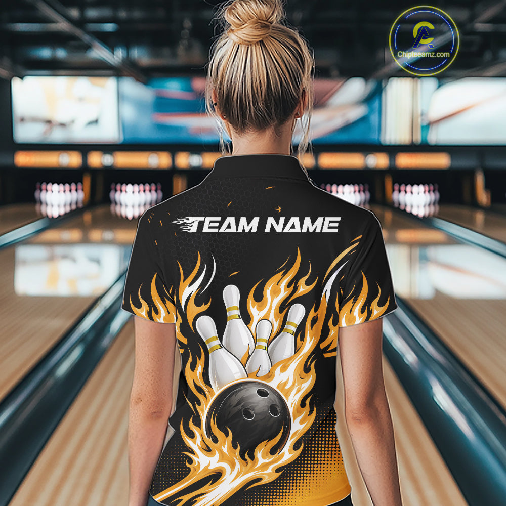 A woman viewed from behind wearing a black short-sleeve bowling shirt with a large graphic of bowling pins, a bowling ball, and orange-yellow flames, with the text 'TEAM NAME' printed across the upper back.