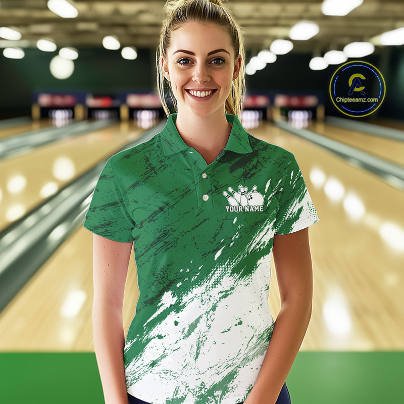 Woman wearing a green and white polo shirt with a logo in a bowling alley.