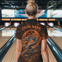 Load image into Gallery viewer, Back view of a female model in a bowling alley wearing an orange custom quarter-zip bowling shirt featuring an ancient dragon, flames, and a moon-inspired bowling ball design.