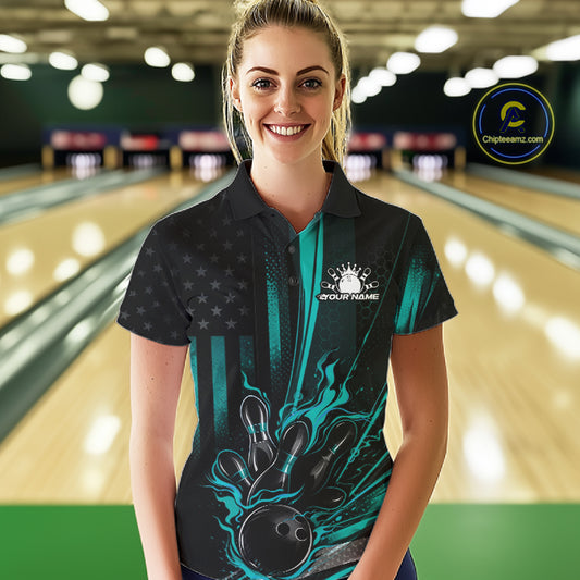 Female model wearing a black and turquoise blue bowling polo shirt at a bowling lane with patriotic bowling strike graphics and flag-inspired accents.