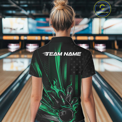 Back view of a female model in a bowling center wearing a black and green polo featuring a bowling ball striking pins with distressed American flag graphics.