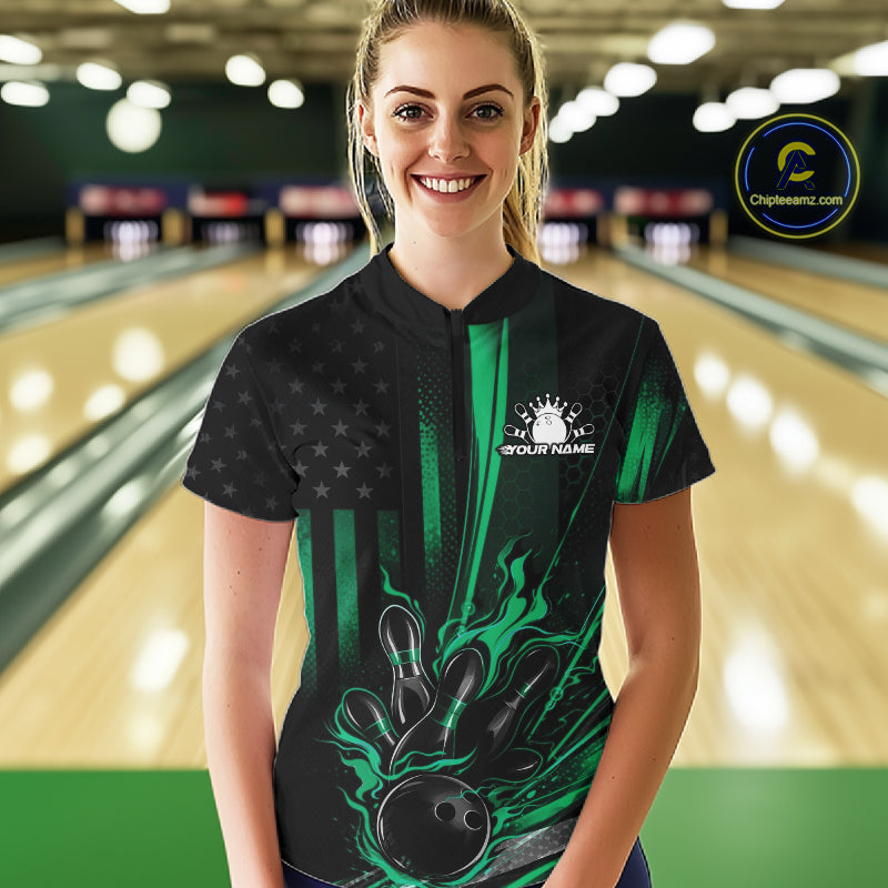 Female model wearing a black and green bowling quarter-zip shirt at a bowling lane with patriotic bowling strike artwork and distressed flag graphics.