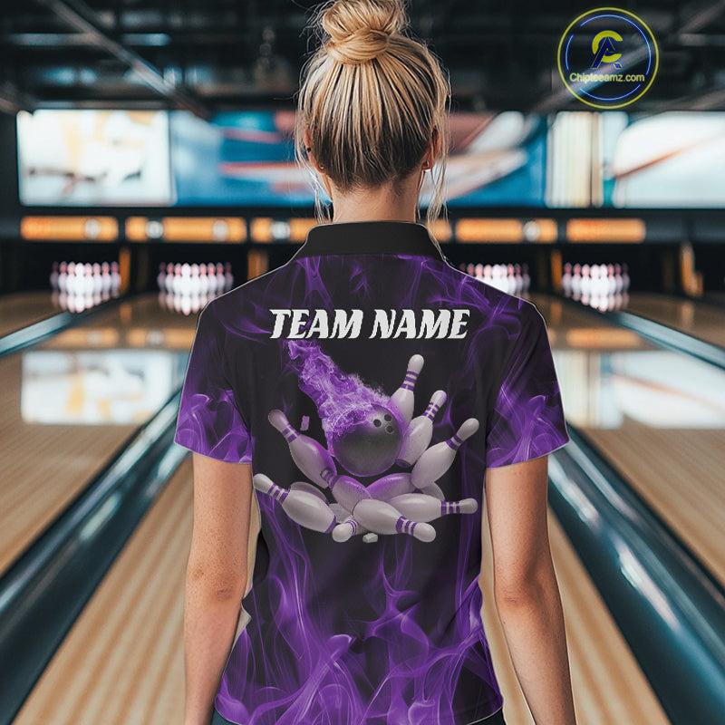 Back view of a female model in a bowling alley wearing a black and purple quarter-zip shirt showcasing a bowling ball and scattered pin motif.