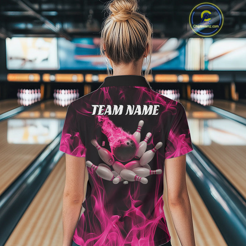 Back view of a female model in a bowling center wearing a black and pink quarter-zip shirt featuring scattered bowling pins and a flame-themed design.