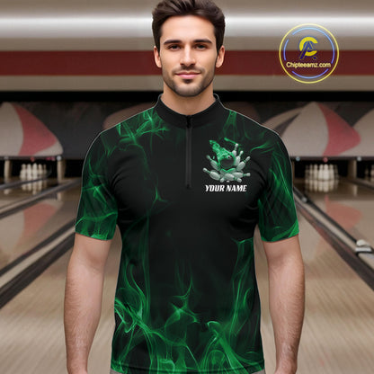Male model at a bowling lane wearing a black and green bowling quarter-zip shirt with bowling strike artwork, scattered pins, and fiery accents.