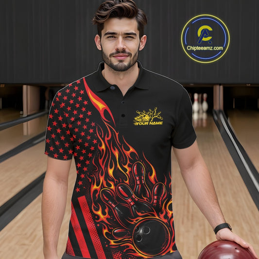 Male model at a bowling lane wearing a black bowling polo shirt with red-orange flame bowling strike artwork and patriotic graphics.