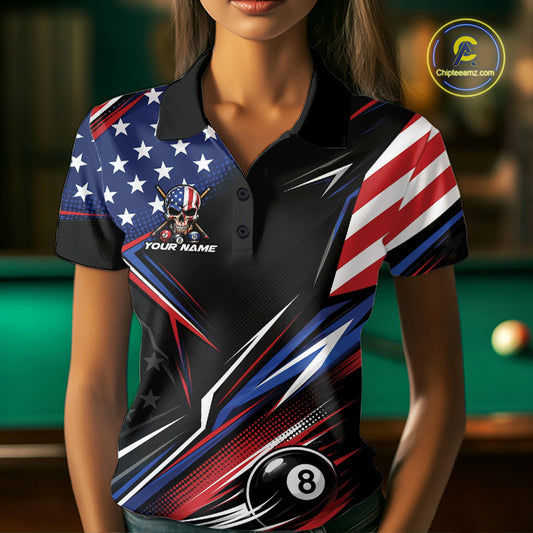 A woman wearing a short-sleeve polo shirt with a patriotic American flag design, featuring red, white, and blue stripes, white stars on a blue background, a skull-and-flag graphic on the chest, and a black 8-ball motif near the hem. 