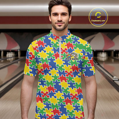 Male model in a bowling lane wearing a multicolored quarter-zip shirt, seamless puzzle pattern design in red, blue, green, and yellow tones.