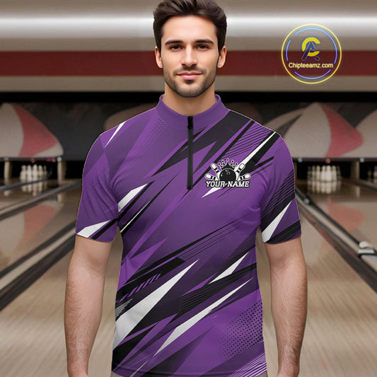 Man wearing a purple bowling shirt with a logo in a bowling alley.