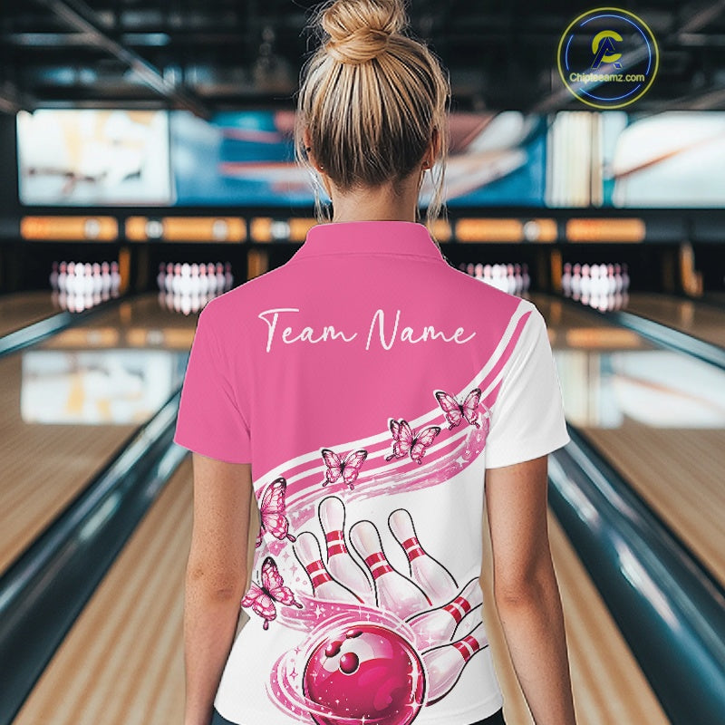 Back view of a female model in a white and pink bowling quarter zip with butterfly artwork and bowling graphics at the bowling lane